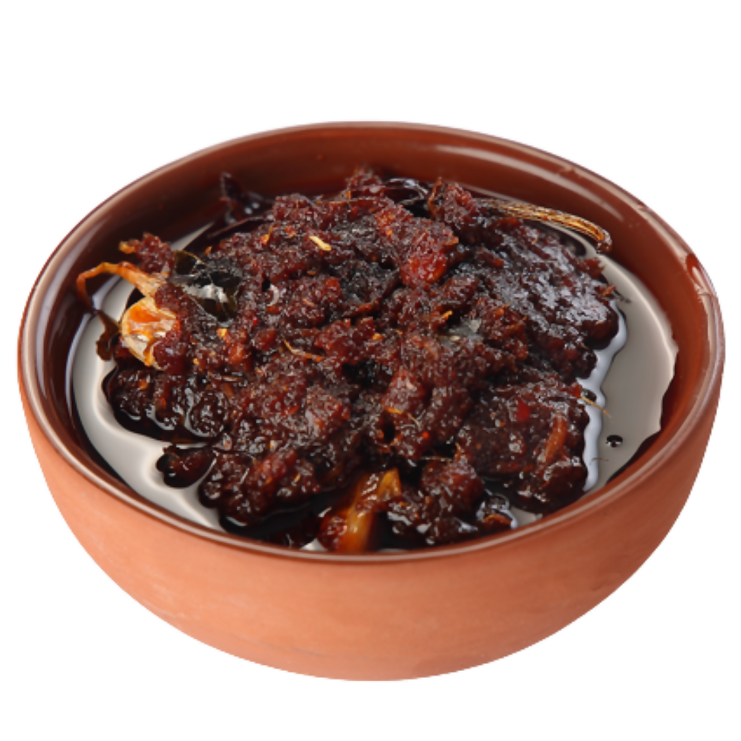 Bowl of dark brown chutney with visible ingredients on a white background