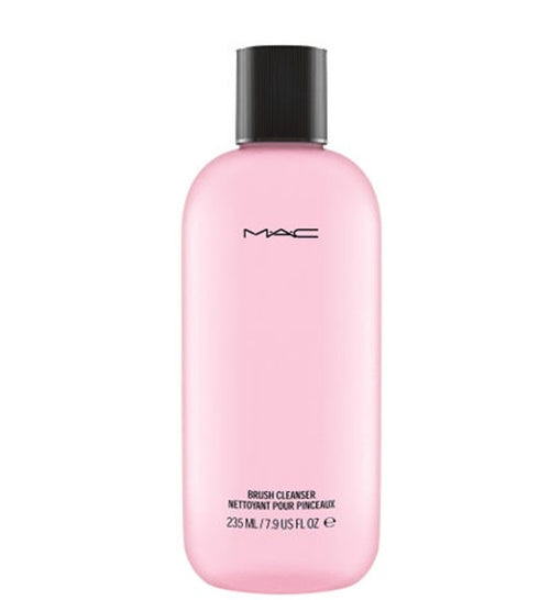 Pink bottle of MAC brush cleanser with black cap on a white background