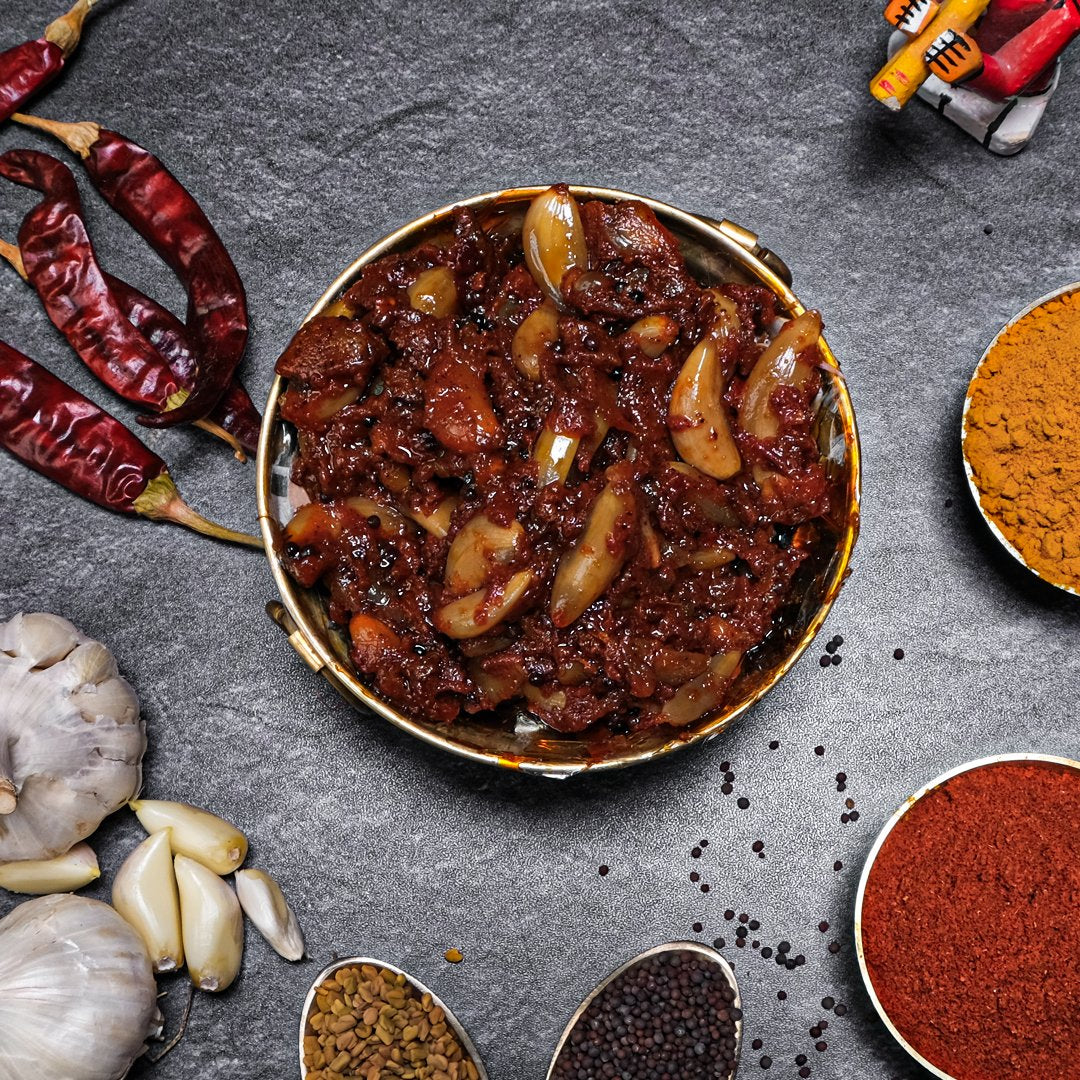 Spicy dish with garlic and red peppers on a dark surface