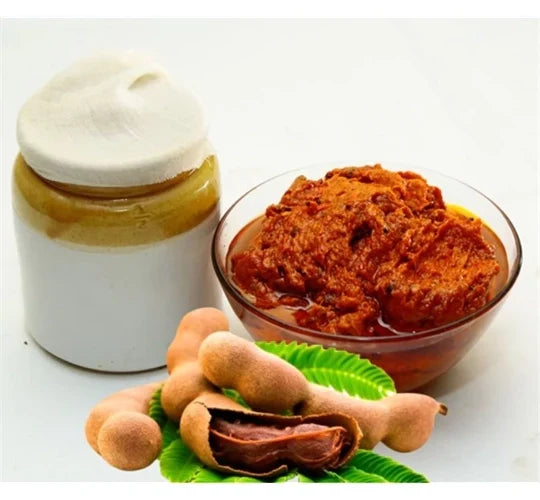 Jar of cream, bowl of brown paste, and tamarind pods on a white background
