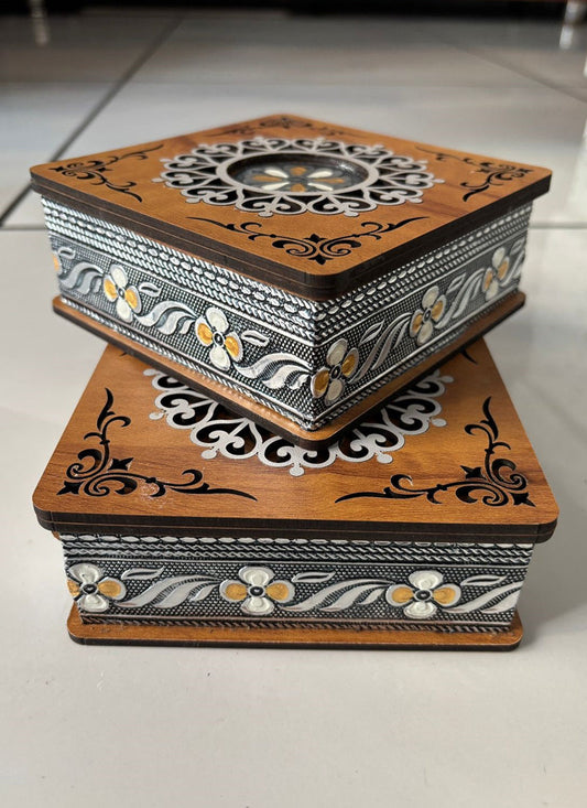 Decorative wooden box with intricate carvings on a light background