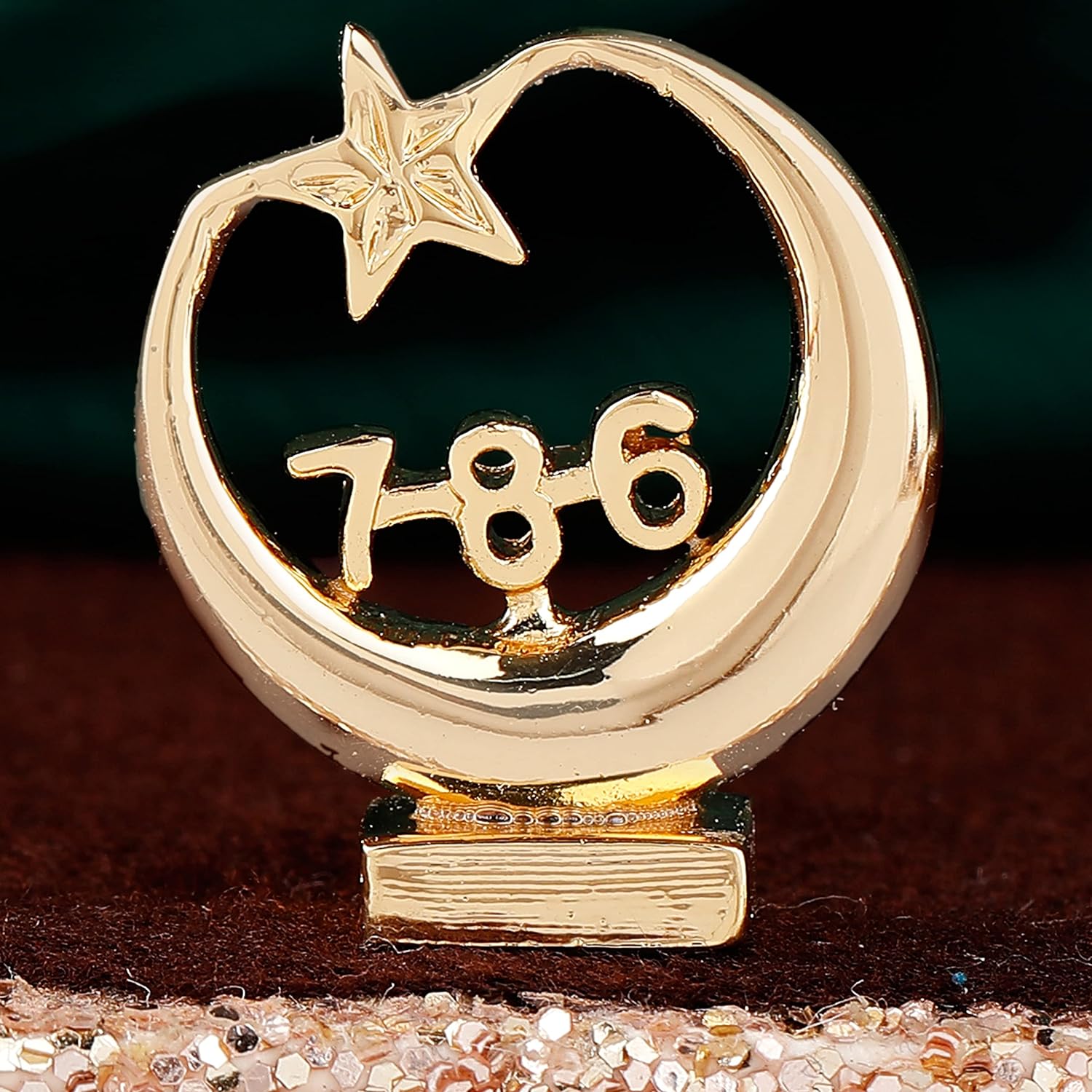 Gold decorative item with a star and number '786' on a dark background