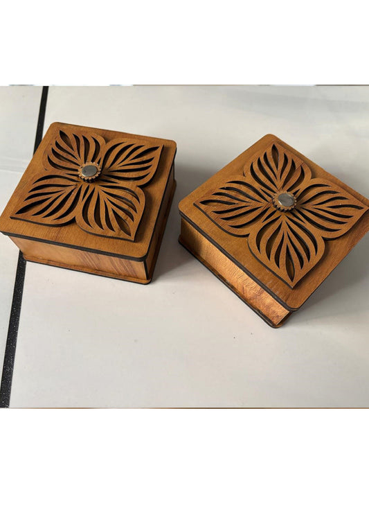 Two wooden boxes with floral carvings on a white surface