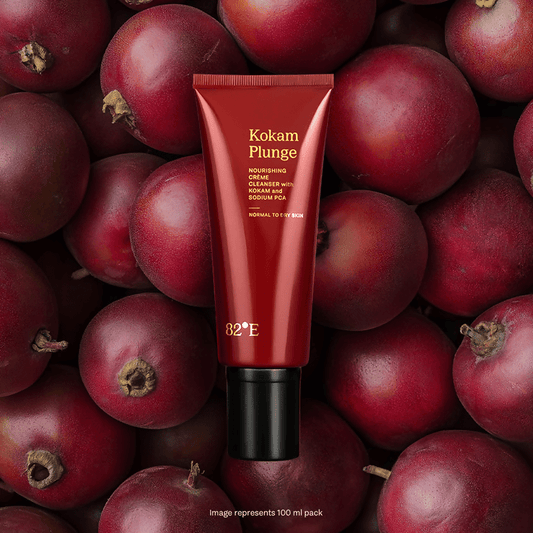 Red skincare product tube labeled 'Kokam Plunge' on a background of red fruits.