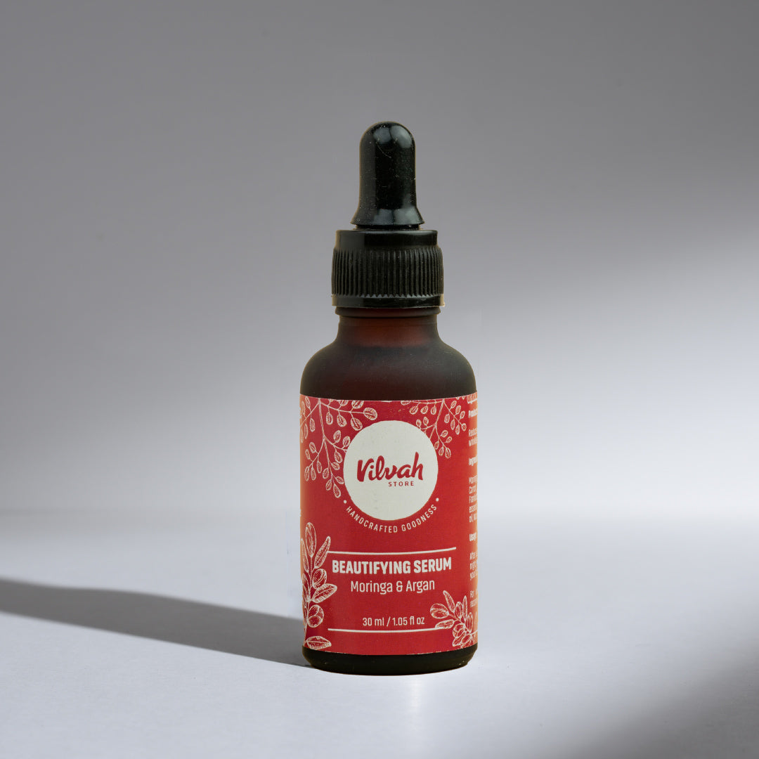 Bottle of Vilvah Beautifying Serum with a red label on a gray background