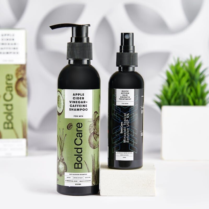 Two hair care products from Bold Care on a white surface with a plant in the background