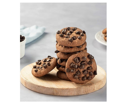 Stack of chocolate chip cookies on a wooden board with a light gray background