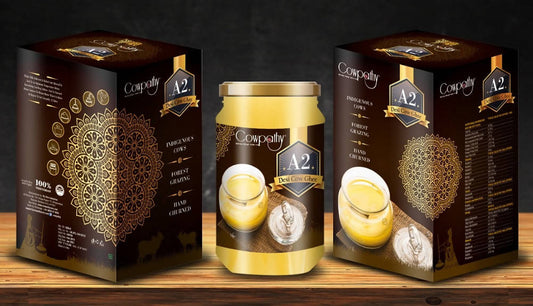 Two jars of Coppenhåg A2 yogurt with their packaging on a wooden surface.