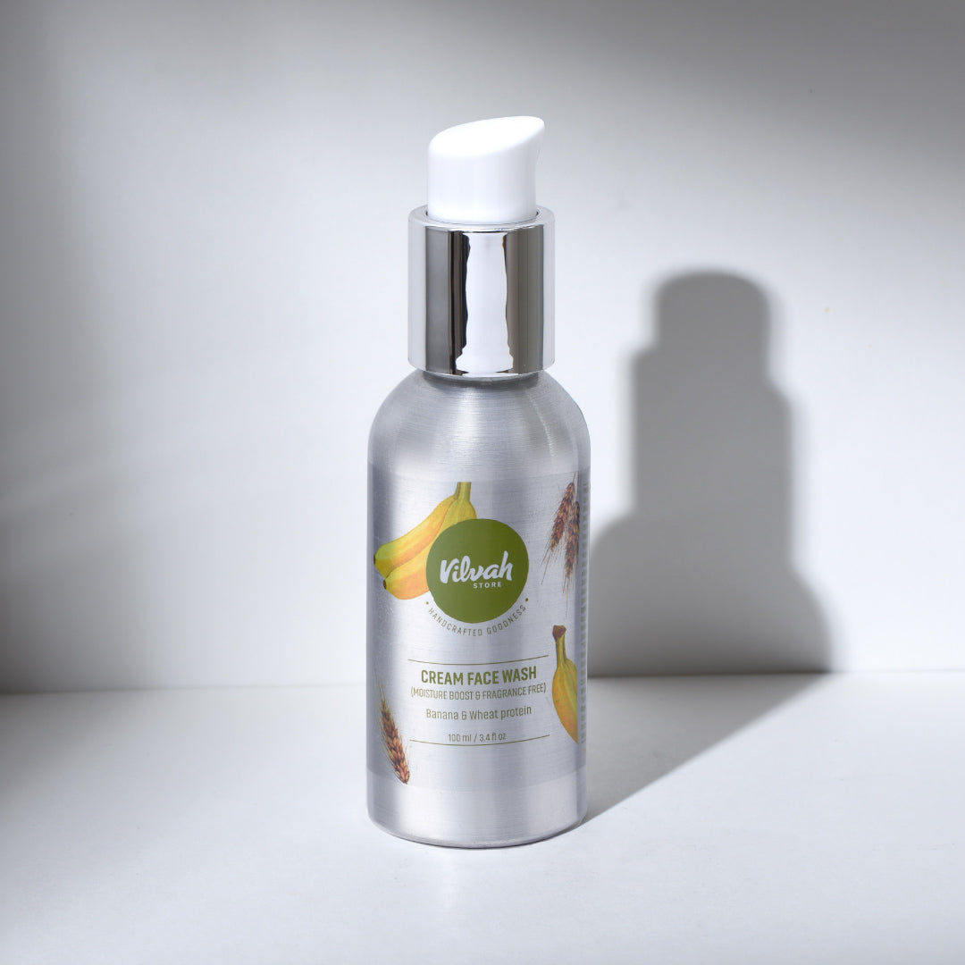 Silver bottle of cream face wash with banana illustration on a white background