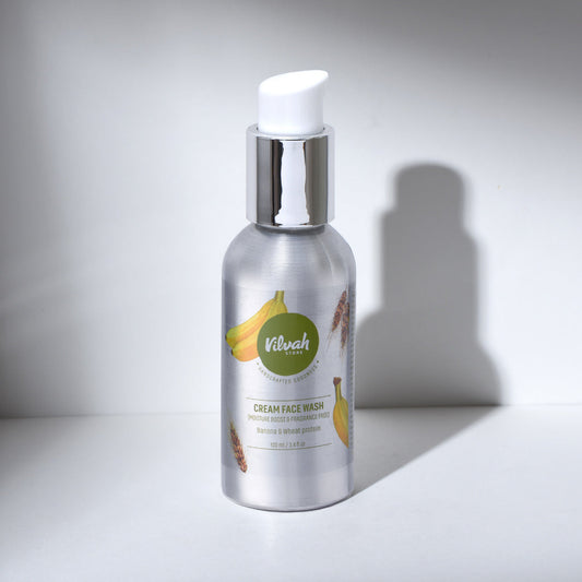 Silver bottle of cream face wash with banana illustration on a white background