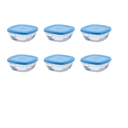 Set of six glass food storage containers with blue lids on a white background