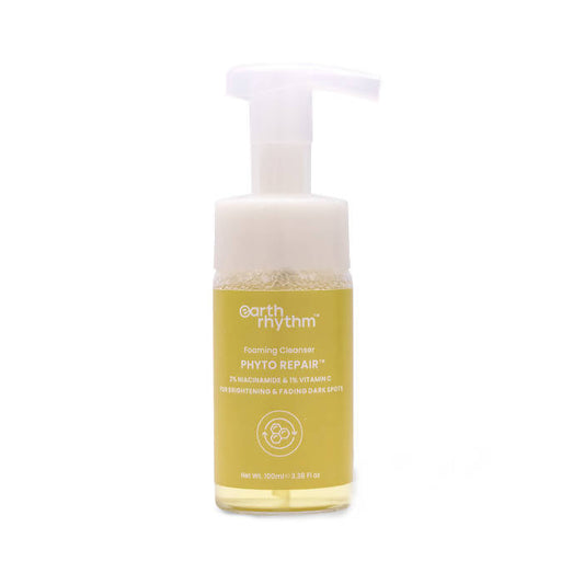 A pump bottle of Earth Rhythm Phyto Repair Foaming Cleanser with a yellowish liquid inside.