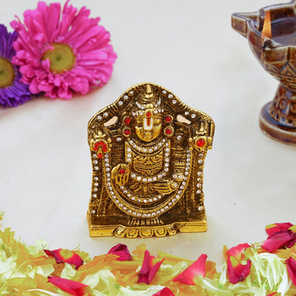 Decorative gold idol with flowers and a lamp on a white background