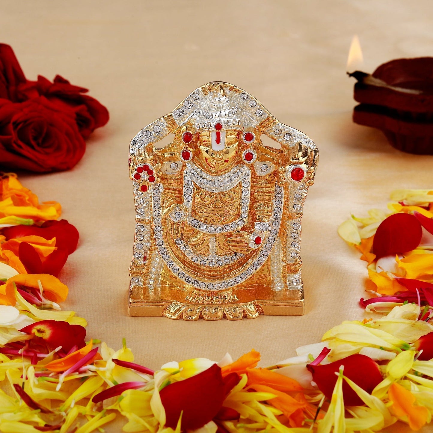Decorative idol with flowers and candles on a beige background
