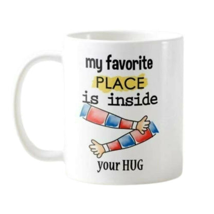 White mug with colorful arms and text 'my favorite place is inside your HUG' on a white background