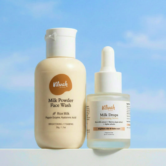 Two skincare products, Milk Powder Face Wash and Milk Drops, by Vilvah against a blue sky background.
