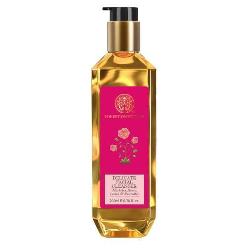 A bottle of Forest Essentials Facial Cleanser with a label showing the brand name and rose illustrations, indicating the scent of rose water.