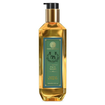 Gold bottle of face wash with a green label on a white background
