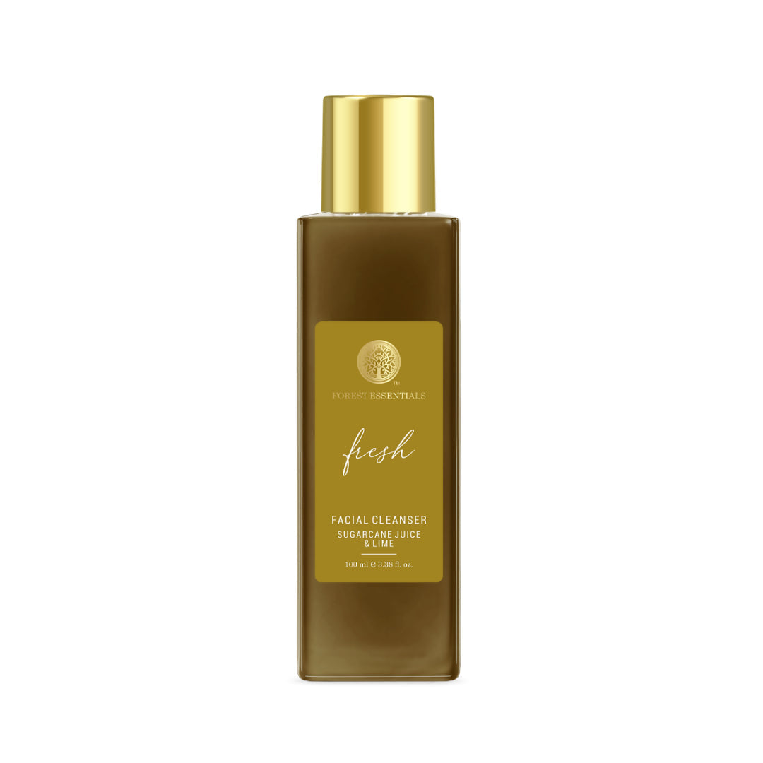 Facial cleanser bottle with gold cap and label on a white background