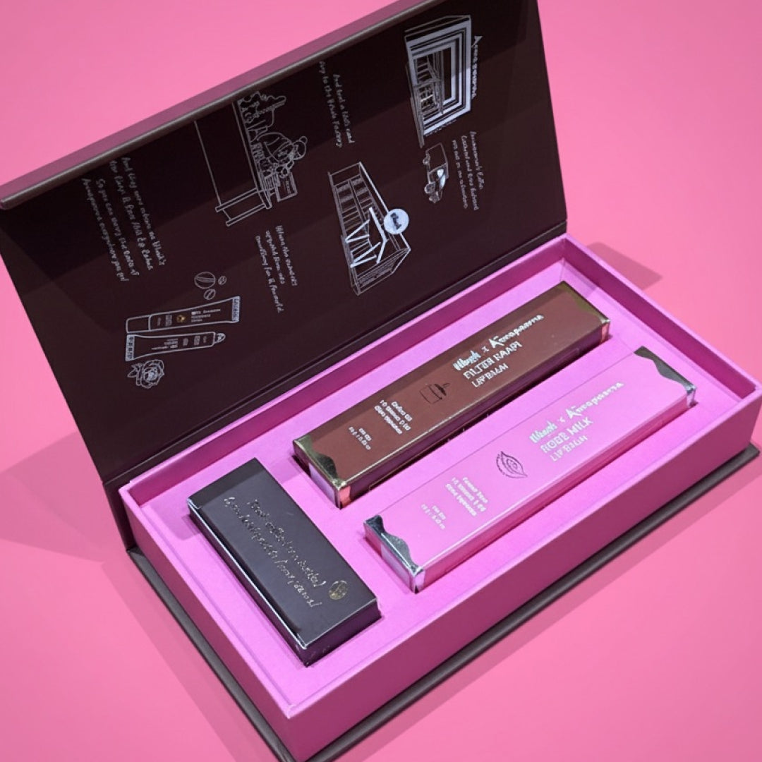 Set of lip products in an open box on a pink background