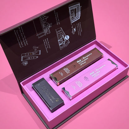 Set of lip products in an open box on a pink background
