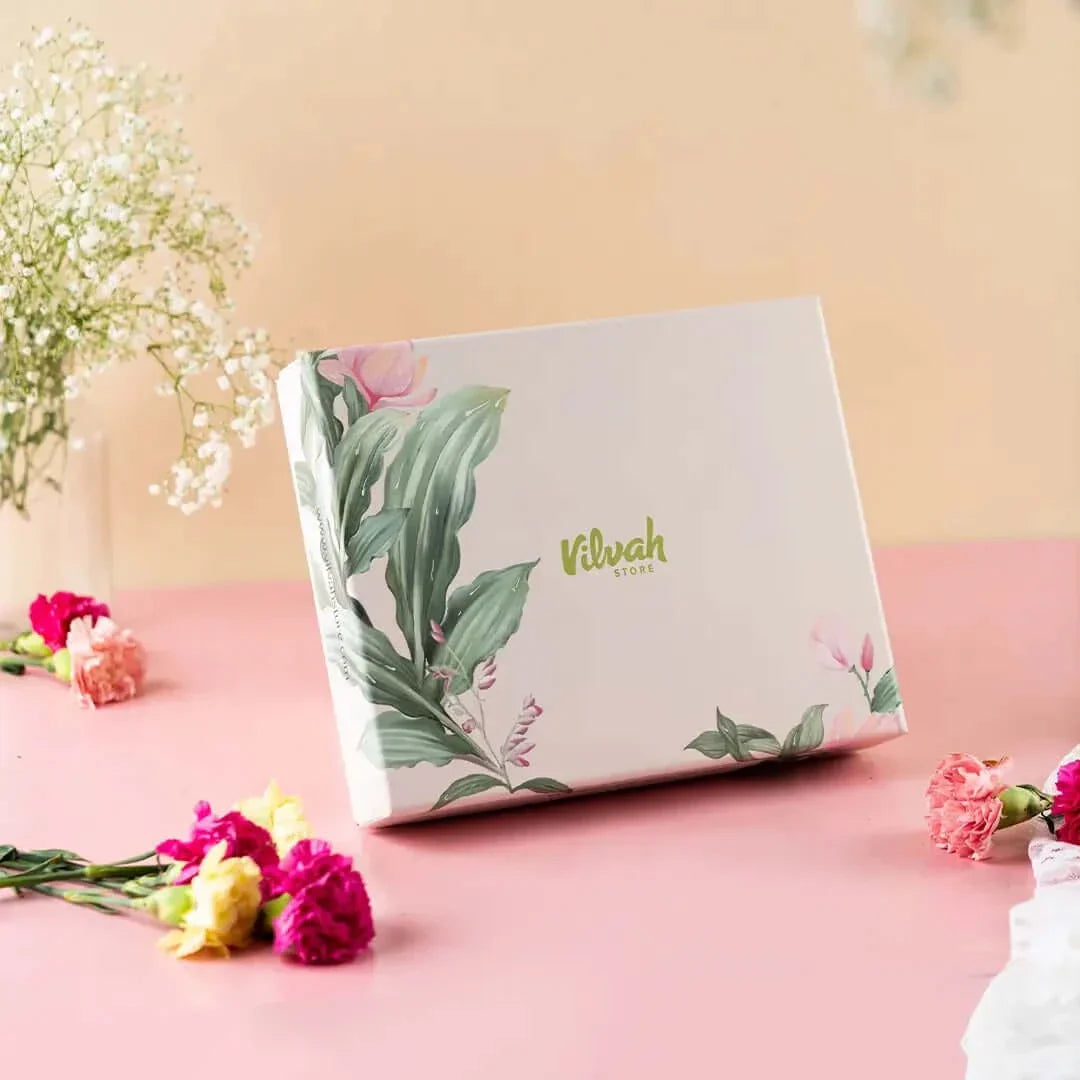 Product packaging with floral design on a pink surface with flowers around