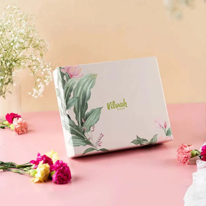 Product packaging with floral design on a pink surface with flowers around