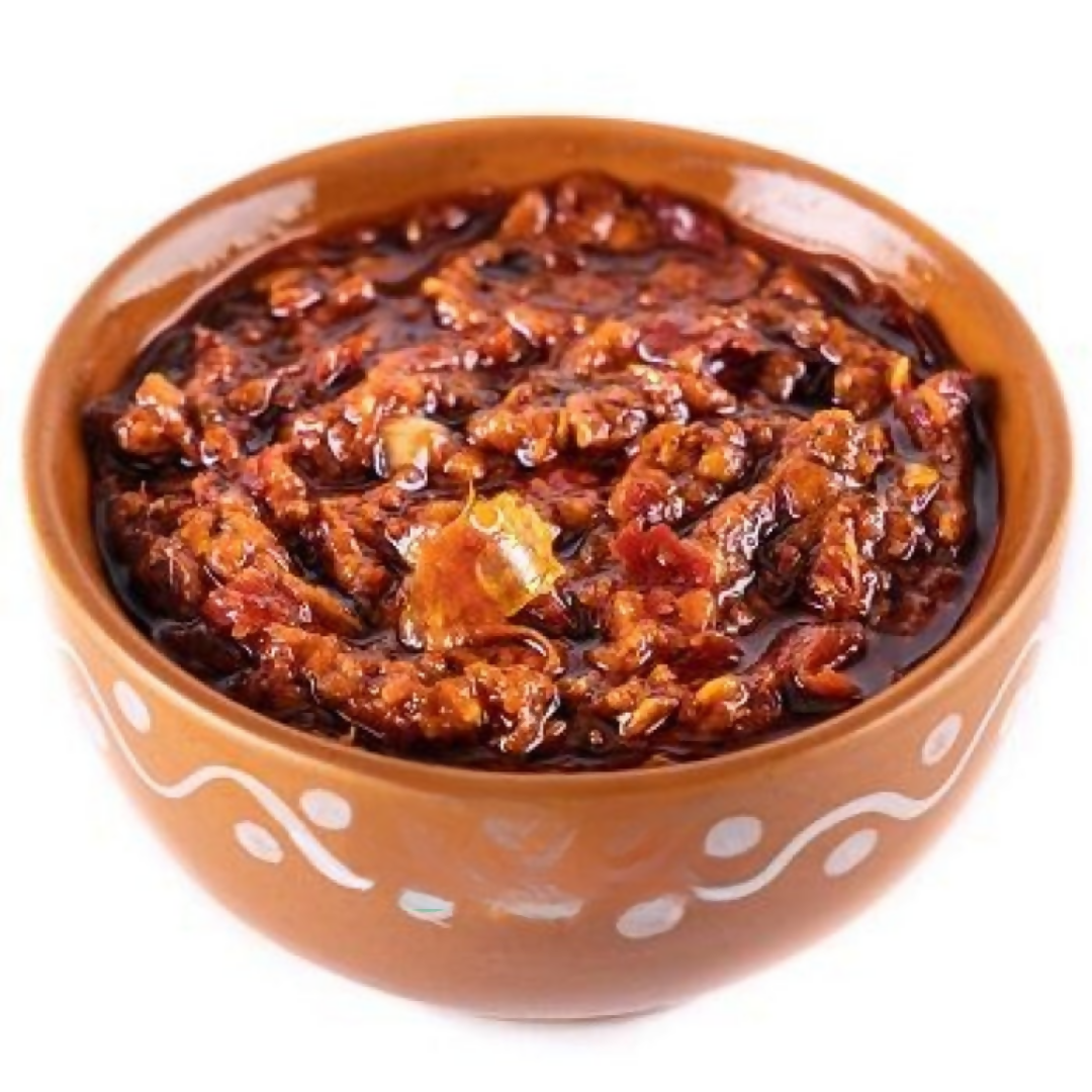 Spicy red sauce in a terracotta bowl on a white background