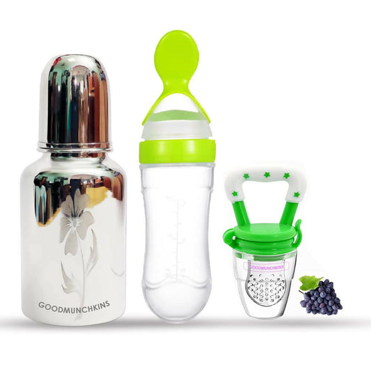 Set of baby feeding products including a bottle, feeder, and pacifier with grapes on a white background.
