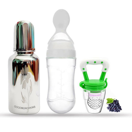 Set of baby bottles and a pacifier with grapes on a white background