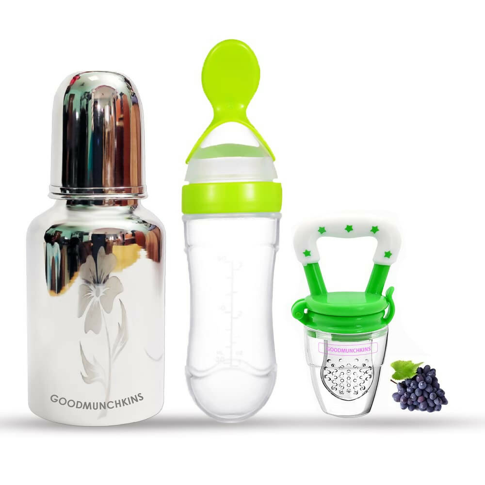 Set of baby feeding products including a bottle, feeder, and pacifier with grapes on a white background.