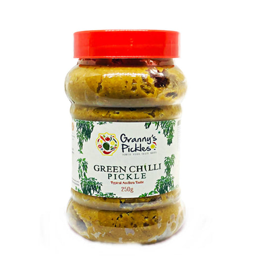 Jar of green chilli pickle with a red lid on a white background