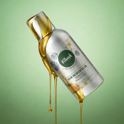 Bottle of Vilash hair regrowth oil with oil dripping, on a green background