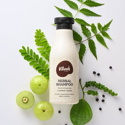 Vilvah Herbal Shampoo bottle with green leaves and fruits on a white background