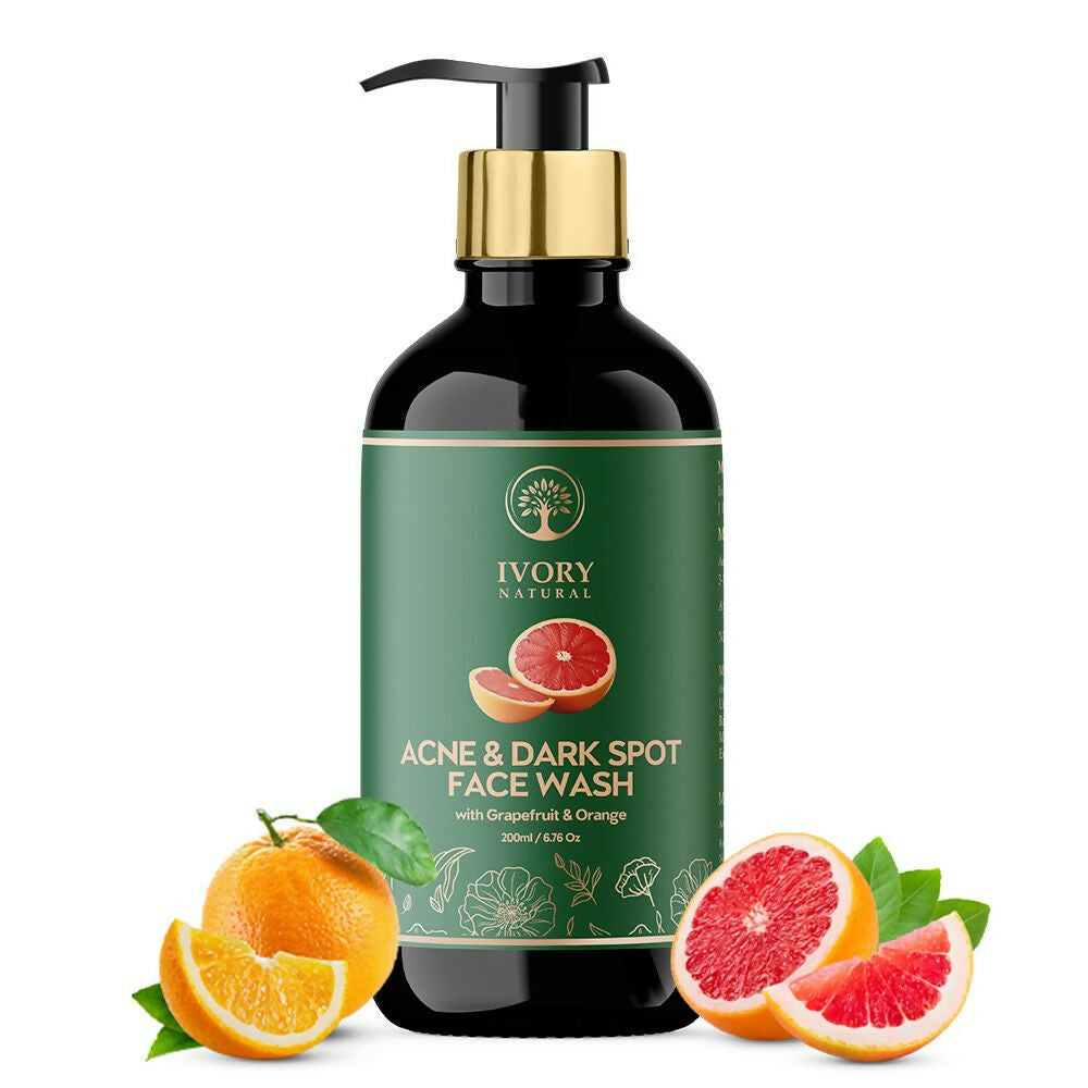 Ivory Natural acne and dark spot face wash bottle with grapefruit and orange slices on a white background