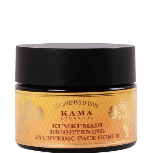 A jar of Kama Ayurveda Kumkumadi Brightening Ayurvedic Face Scrub with a black lid and a label that has gold and white design elements.