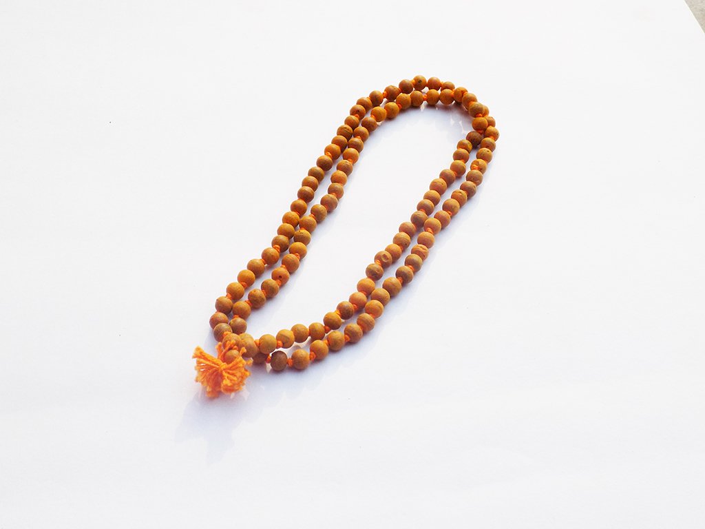 Brown beaded necklace with a tassel on a white background