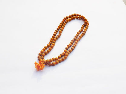 Brown beaded necklace with a tassel on a white background