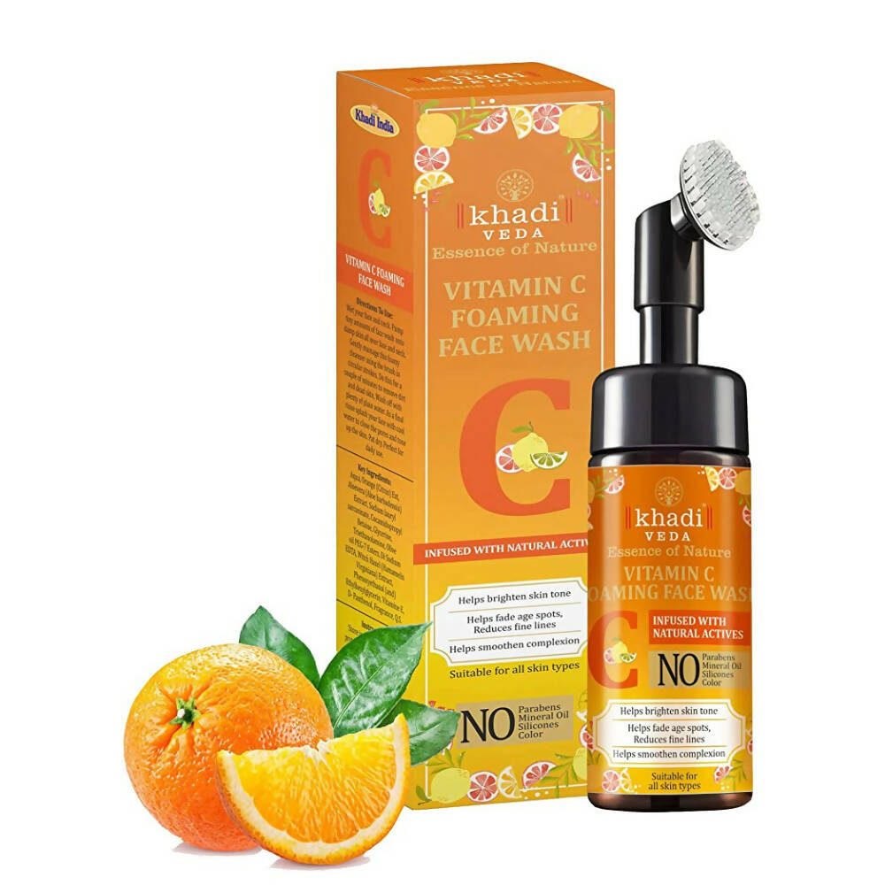 Khadi Veda Vitamin C Foaming Face Wash with packaging, oranges, and leaves on a white background