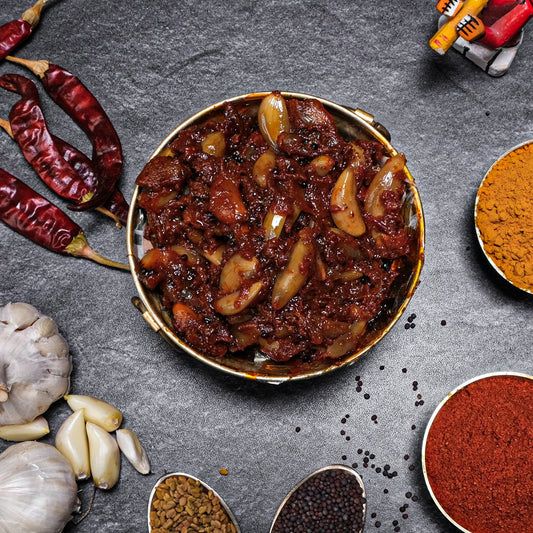 Spicy dish with garlic and red peppers on a dark surface