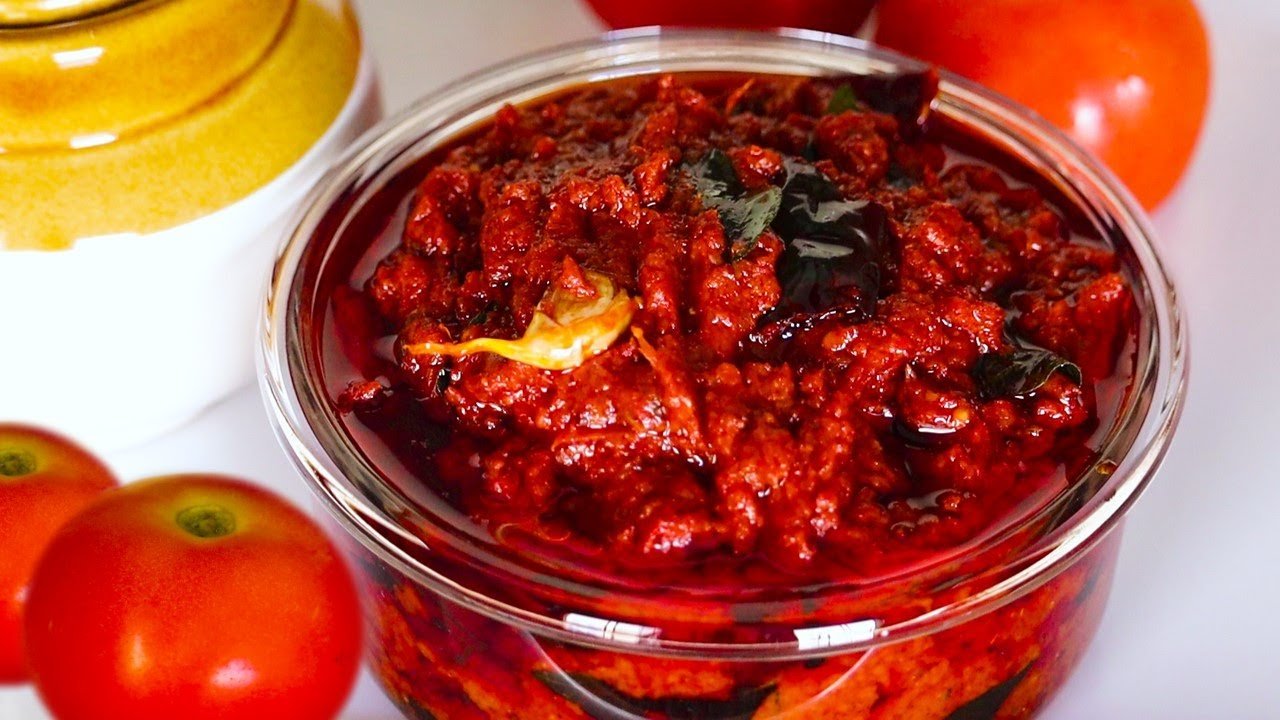 Jar of red chili paste with tomatoes on a white background
