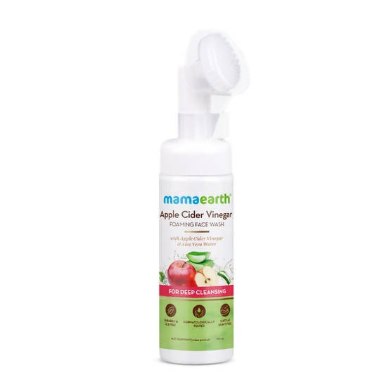 A bottle of Mamaearth Apple Cider Vinegar Foaming Face Wash with a soft silicone brush applicator on the top. The label on the bottle shows the product name and mentions that it's suitable for deep cleansing.