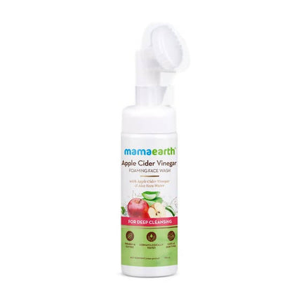 A bottle of Mamaearth Apple Cider Vinegar Foaming Face Wash with a soft silicone brush applicator on the top. The label on the bottle shows the product name and mentions that it's suitable for deep cleansing.