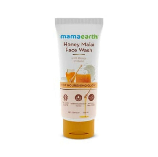 A tube of Mamaearth Honey Malai Face Wash with illustrations of honey and milk, indicating nourishing properties.