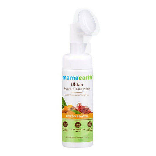 A pump bottle of Mamaearth Ubtan Foaming Face Wash with a built-in soft brush, labeled for tan removal.