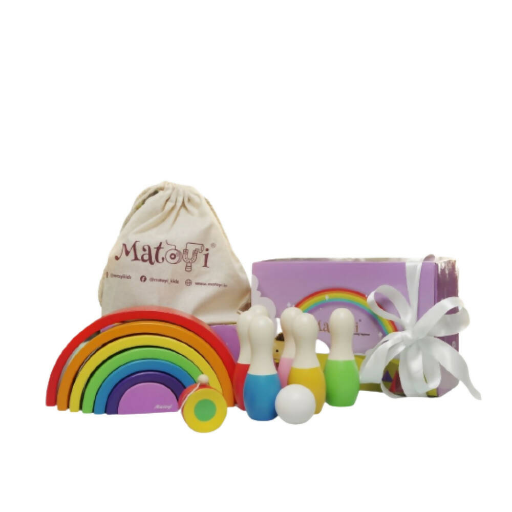 Colorful wooden toys including a rainbow-shaped block and small bowling pins, with a branded drawstring bag and packaging on a white background.