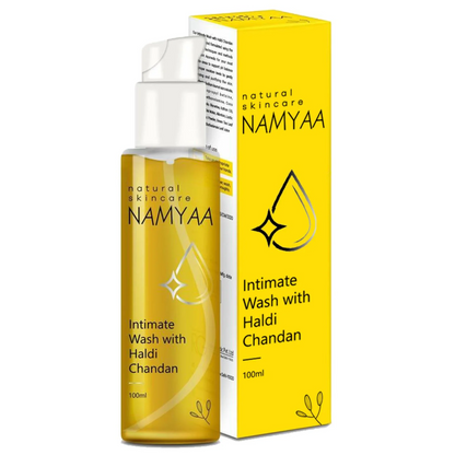 The image shows a yellow-colored packaging for Namyaa Intimate Wash with Haldi Chandan. The box is visible with product information, and a clear bottle of the wash is displayed in front, indicating the texture and color of the product.