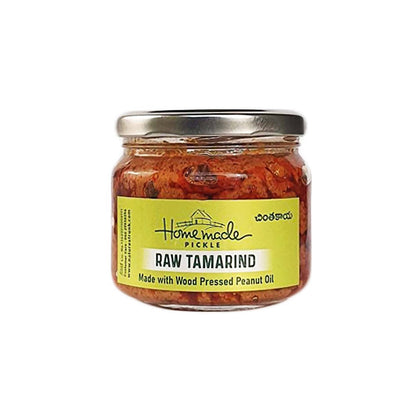 Jar of raw tamarind pickle with a yellow label on a white background