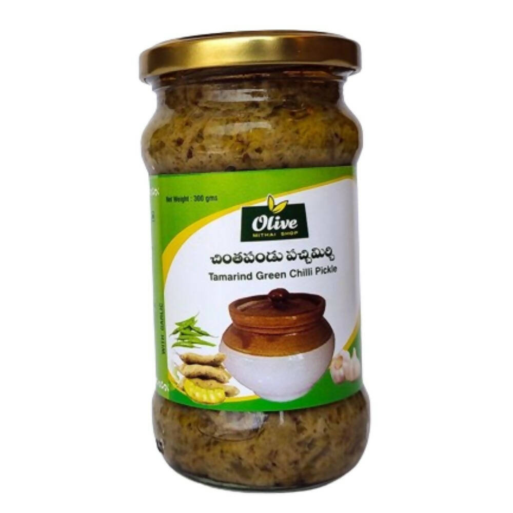 Jar of tamarind green chili pickle with a gold lid on a white background
