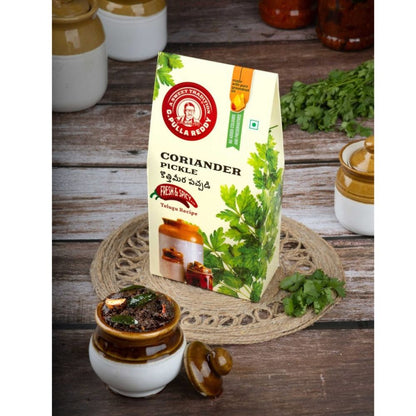 D. K. Malla Reddy Coriander Pickle packaging on a wooden surface with coriander leaves.